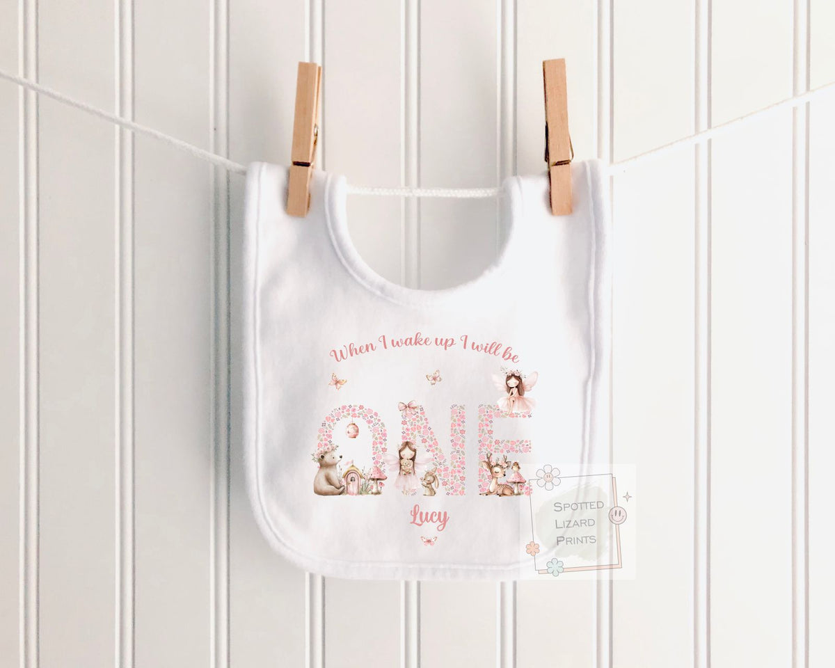 Personalised 1st birthday girl outfit with fairies, woodland animals and floral ONE design. Add her name and choose a bib, baby vest or sleepsuit.