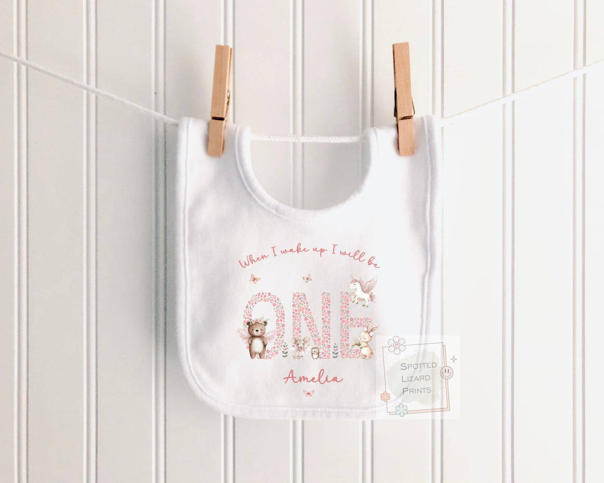 Personalised 1st birthday girl outfit with floral ONE and cute woodland animals. Add her name and choose a personalised bib, baby vest or sleepsuit.