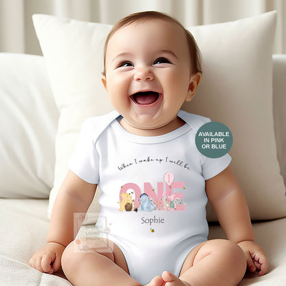 Personalised 1st birthday baby outfit available in pink or blue. Add their name and choose a first birthday bib, baby vest or sleepsuit for their special day.