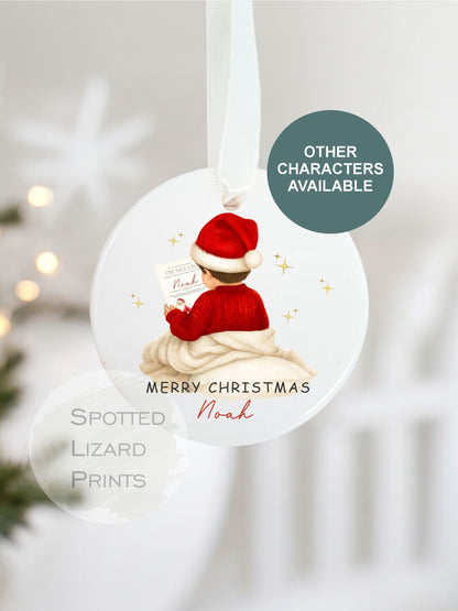Christmas-themed ornament with a child in a Santa hat and red sweater, featuring 'Spotted Lizard Prints' branding.