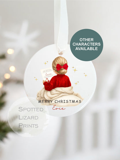 Christmas ornament with a child in a red sweater and bow, featuring 'Spotted Lizard Prints' branding.